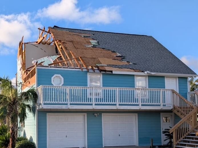Severe roof and framing damage on a two-story coastal home caused by Hurricane Isaias.